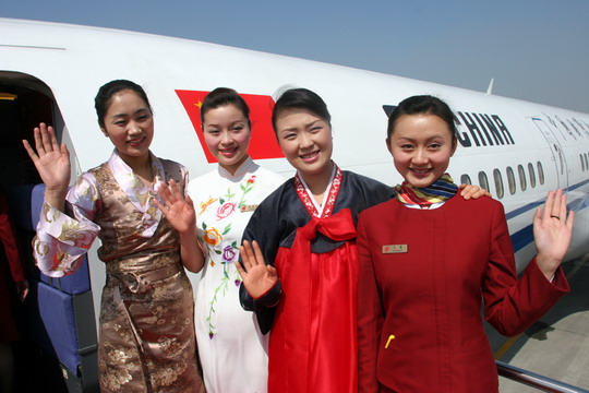 图2:藏族空乘达娃卓玛(左一)、朝鲜族空乘金成淑(右二)和身穿旗袍的陈菲菲(左二)在舱门迎接代表登机